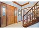 Welcoming foyer featuring hardwood floors, staircase with wood banister, and a stylish wooden front door at 12082 Old Stone Dr, Indianapolis, IN 46236