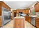 Traditional kitchen with stainless steel appliances, center island, and warm wood cabinetry offering ample storage at 12082 Old Stone Dr, Indianapolis, IN 46236