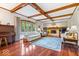 Bright living room featuring hardwood floors, a cozy fireplace, coffered ceiling, and large windows at 12082 Old Stone Dr, Indianapolis, IN 46236