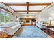 Spacious living room with wood flooring, fireplace, exposed beams, and large area rug at 12082 Old Stone Dr, Indianapolis, IN 46236