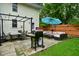 This backyard features an outdoor dining and patio furniture set, a grill, a blue umbrella, and a well-kept lawn at 1236 Central Ave, Indianapolis, IN 46202