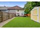 Well-maintained backyard with a shed, patio furniture, lush green grass, and secure fencing at 1236 Central Ave, Indianapolis, IN 46202