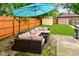 Outdoor living space with comfortable seating under a large umbrella in a fenced backyard at 1236 Central Ave, Indianapolis, IN 46202