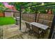 Outdoor dining area with stone tile patio, grill, string lights, and detached garage view at 1236 Central Ave, Indianapolis, IN 46202