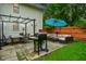Backyard patio view with outdoor seating area, grill, umbrella, and string lights at 1236 Central Ave, Indianapolis, IN 46202