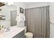 Well-lit bathroom featuring a gray vanity, modern fixtures, and a shower with gray curtain at 1236 Central Ave, Indianapolis, IN 46202