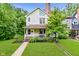 Charming two-story home featuring a cozy front porch, mature landscaping, and a well-maintained lawn at 1236 Central Ave, Indianapolis, IN 46202