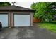 This garage features two garage doors, a side door, and a well-kept lawn at 1236 Central Ave, Indianapolis, IN 46202