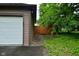 This garage features a side door, a two-car garage door, and a well-kept lawn at 1236 Central Ave, Indianapolis, IN 46202