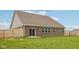 View of the spacious backyard featuring a well-maintained lawn and wood privacy fence at 1270 Shaw Ln, Shelbyville, IN 46176