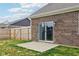 Backyard view showcasing a brick home exterior, concrete patio, and fenced yard at 1270 Shaw Ln, Shelbyville, IN 46176