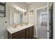 Bathroom featuring a double sink vanity with a large mirror, modern lighting, and neutral decor at 1270 Shaw Ln, Shelbyville, IN 46176