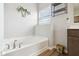 Bright bathroom featuring a soaking tub, window, modern fixtures, and decorative accents at 1270 Shaw Ln, Shelbyville, IN 46176