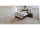 Large bedroom with gray walls and carpet featuring bedside lamps, and windows overlooking the neighborhood at 1270 Shaw Ln, Shelbyville, IN 46176