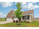 Charming brick home featuring a large three car garage, front porch, and landscaped yard at 1270 Shaw Ln, Shelbyville, IN 46176