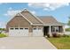 Charming brick home featuring a large three car garage and well-manicured lawn at 1270 Shaw Ln, Shelbyville, IN 46176