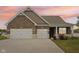 Inviting exterior showcasing a well-manicured lawn and a spacious three-car garage at 1270 Shaw Ln, Shelbyville, IN 46176