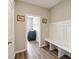 Mudroom with gray walls and hardwood floor that leads to a laundry room featuring a bench with hooks at 1270 Shaw Ln, Shelbyville, IN 46176