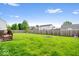 The backyard has green grass, a stone firepit, and a fenced perimeter at 12832 Broncos Dr, Fishers, IN 46037