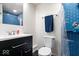 Modern bathroom with blue tiled shower, vanity with a white countertop, and toilet at 12832 Broncos Dr, Fishers, IN 46037