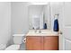 Cozy half-bath features a wood vanity, cream countertop, toilet and a large mirror at 12832 Broncos Dr, Fishers, IN 46037