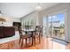 Dining area with wood floors, a sliding glass door to the deck, and seamless flow to living room at 12832 Broncos Dr, Fishers, IN 46037
