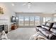 Open-concept living room with a fireplace, large windows, and access to the dining area and kitchen at 12832 Broncos Dr, Fishers, IN 46037