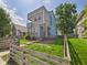 Contemporary two-story home featuring blue and gray siding, a small balcony, and a charming fenced-in yard at 1409 Spann Ave, Indianapolis, IN 46203