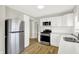 Modern kitchen design with stainless steel appliances, white cabinets, updated countertops, and stylish flooring at 1515 S Emerson Ave, Indianapolis, IN 46203
