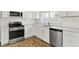 Modern kitchen features sleek stainless steel appliances, white cabinets, granite countertops, and wood-look flooring at 1515 S Emerson Ave, Indianapolis, IN 46203