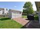 Backyard view featuring a storage shed, lush green grass and a brick patio for outdoor enjoyment at 1652 Sweetwater Ln, Greenfield, IN 46140