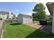 Backyard view featuring a storage shed, lush green grass and a brick patio for outdoor enjoyment at 1652 Sweetwater Ln, Greenfield, IN 46140