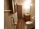 A bathroom with accessibility features including a grab bar, wood-look floors, and wooden cabinets at 1652 Sweetwater Ln, Greenfield, IN 46140