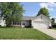 Charming single-story home featuring a well-maintained lawn and attached garage on a sunny day at 1652 Sweetwater Ln, Greenfield, IN 46140