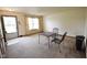 Empty living room featuring neutral carpet, a small table with chairs, and an entry doorway at 1652 Sweetwater Ln, Greenfield, IN 46140