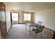 Bright empty living room featuring neutral carpet, a small table with chairs, and an entry doorway at 1652 Sweetwater Ln, Greenfield, IN 46140