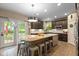 Spacious kitchen features a large island with seating, granite countertops, and dark wood cabinets at 17002 Folly Brook Rd, Noblesville, IN 46060
