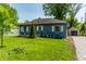 Beautiful single-story home on a well-manicured lawn with a detached garage and a driveway at 1747 S Irvington Ave, Indianapolis, IN 46203