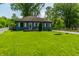 Charming one-story home with a well-maintained lawn, mature trees, and a gravel driveway at 1747 S Irvington Ave, Indianapolis, IN 46203