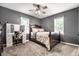 Cozy bedroom with two windows, a ceiling fan, and a vanity and desk area with a chair at 1747 S Irvington Ave, Indianapolis, IN 46203
