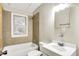 Small tiled bathroom with a standard bathtub and white porcelain sink at 1852 N Warman Ave, Indianapolis, IN 46222