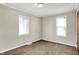 Bright bedroom with two windows, neutral walls and carpet flooring at 1852 N Warman Ave, Indianapolis, IN 46222