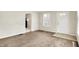 A spacious carpeted living room featuring an entry door and view to kitchen at 1852 N Warman Ave, Indianapolis, IN 46222
