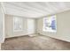 A bright living room with two windows, carpeted floors, and a front door at 1852 N Warman Ave, Indianapolis, IN 46222