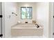 Bright bathroom featuring a soaking tub beneath a window offering natural light at 1941 Orchard Ct, Carmel, IN 46280