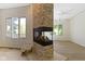 Modern stone fireplace dividing two spaces with light hardwood floors and natural light at 1941 Orchard Ct, Carmel, IN 46280