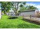 Expansive backyard with a well-maintained lawn, wooden deck, and mature trees for shade at 2150 S Emerson Ave, Indianapolis, IN 46203