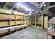 Unfinished basement showing exposed ceiling, water pipes, and built-in wooden shelves at 2150 S Emerson Ave, Indianapolis, IN 46203