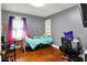 This bedroom features a bed, wood floors, and a window that provides natural light at 2150 S Emerson Ave, Indianapolis, IN 46203