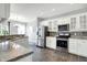 Well-appointed kitchen with white cabinets, stainless steel appliances, and a view of the dining area at 2473 Shadow Bend Dr, Columbus, IN 47201